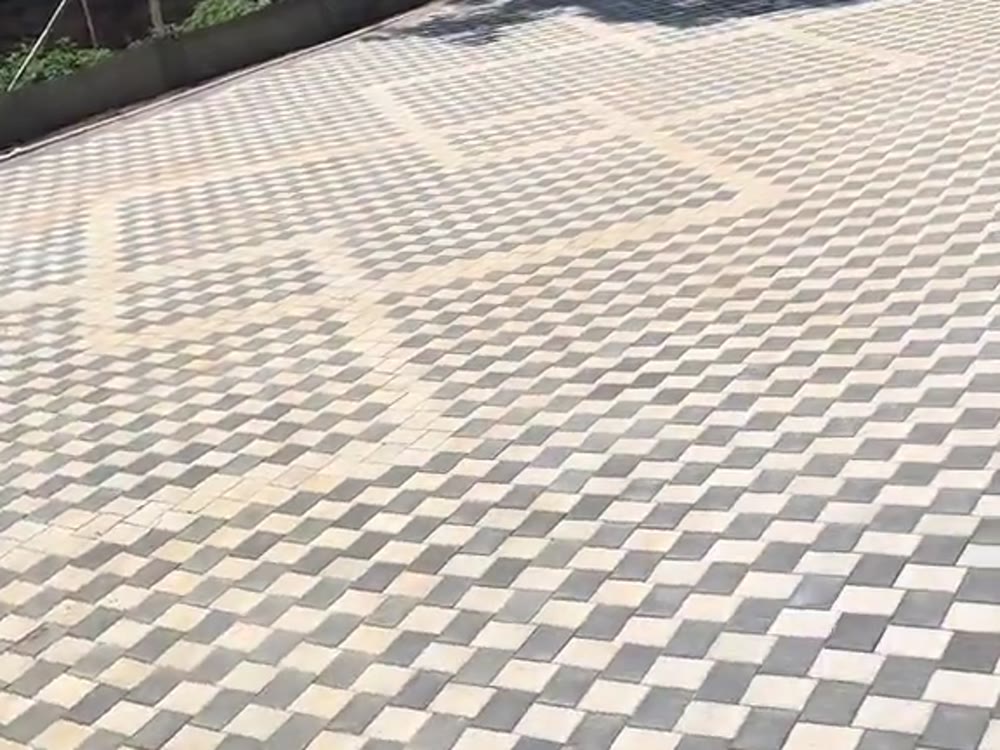 Finished checkerboard interlocking paver driveway in cream and charcoal