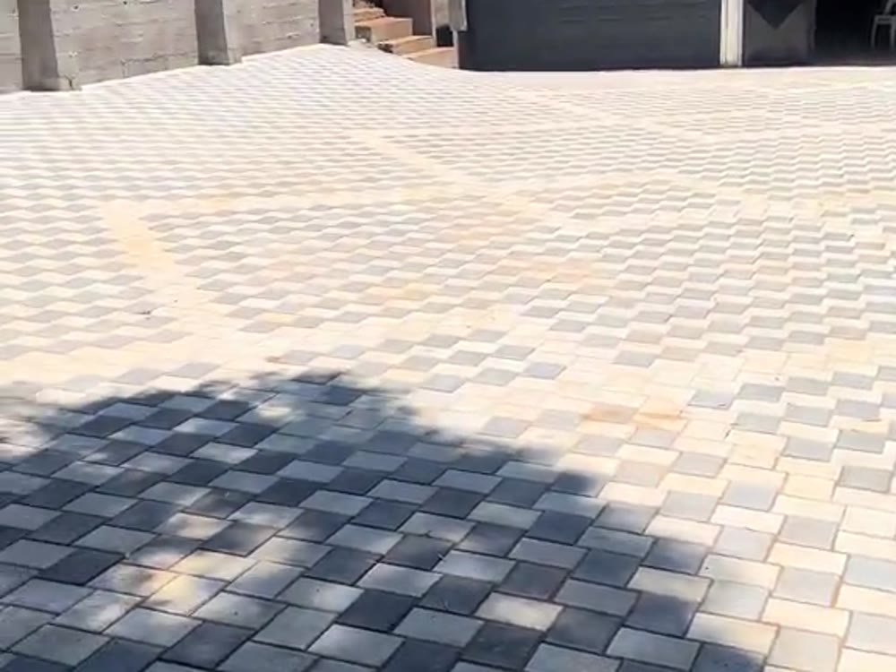 Charcoal cobble paved driveway sweeping up to a garage